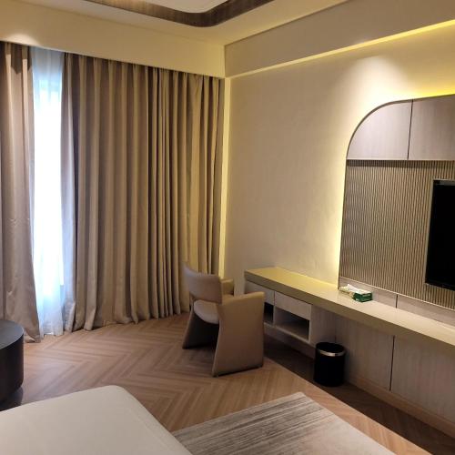 a hotel room with a desk and a television at The Tivoli New Delhi in New Delhi