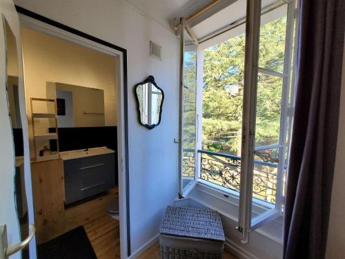 un couloir avec une grande fenêtre et une salle de bains. dans l'établissement Le Beau Site, à Aix-les-Bains