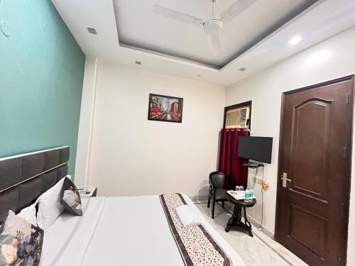 a bedroom with a bed and a door and a chair at South Inn - Green Park South Delhi in New Delhi