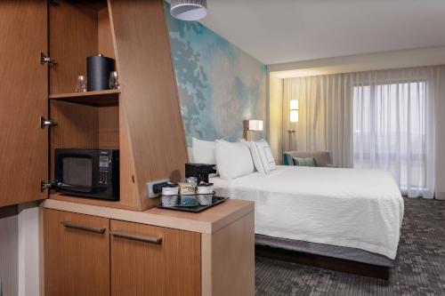 メイソンにあるCourtyard Cincinnati Masonのベッドとテレビがあるホテルの部屋