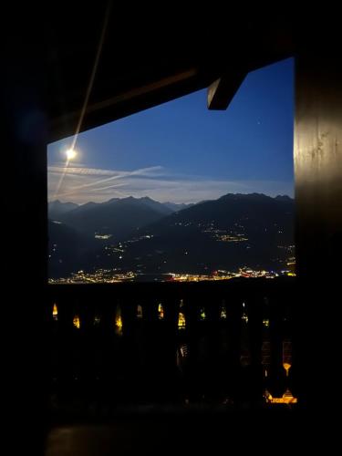 a view from a window of a city at night at 3,5 Zimmer Attikawohnung mit Traumaussicht in Arbaz