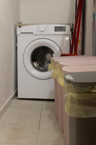 a white washing machine in a laundry room with a counter at Domo de Ciu Nenneddu in Oliena