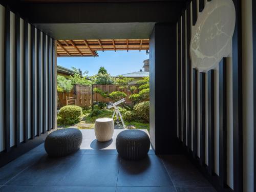 a room with three chairs and a large window at Sekitaitei Ishida in Achi