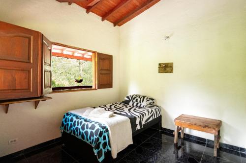 a room with two beds and a window at Hotel Orillas del Pizano in Jardin