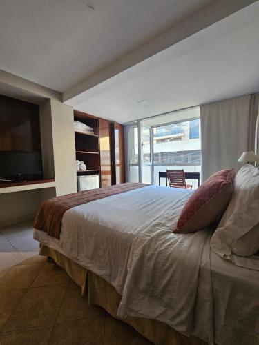 a bedroom with a large bed and a television at Departamento Caseros in Salta