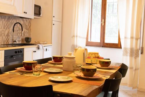 a kitchen with a wooden table with bowls on it at Domo de Ciu Nenneddu in Oliena