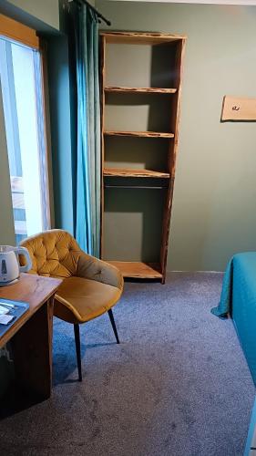 a room with a chair and a book shelf at Pokoje u Daniela in Miedzygorze