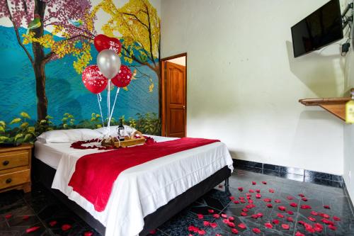 a bedroom with a bed with balloons on it at Hotel Orillas del Pizano in Jardin