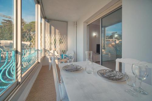 une table blanche avec des assiettes et des verres sur un balcon dans l'établissement Immogroom -Studio-Clim-Sea view, à Cannes