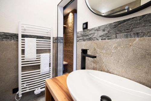 a bathroom with a white sink and a mirror at AlpinSpa zur Post Apartment - Bergbahn im Sommer 2025 inklusive in Bad Gastein