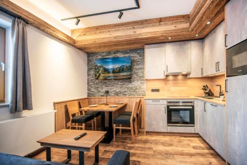 a kitchen with a table and a dining room at AlpinSpa zur Post Apartment - Bergbahn im Sommer 2025 inklusive in Bad Gastein