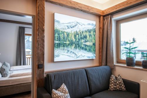 a living room with a couch and windows at AlpinSpa zur Post Apartment - Bergbahn im Sommer 2025 inklusive in Bad Gastein