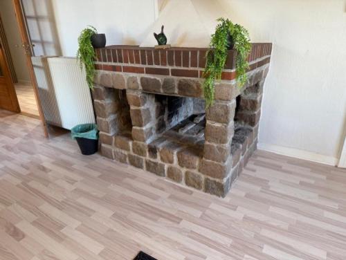 a brick fireplace with plants on top of it at Folsted - Værelse 102 med eget badeværelse og fri parkering in Bindslev
