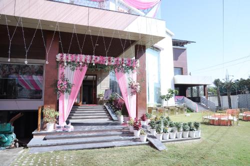 a building with pink curtains and flowers on the stairs at Hotel Chandraa Celebration ISBT Graphic in Dehradun