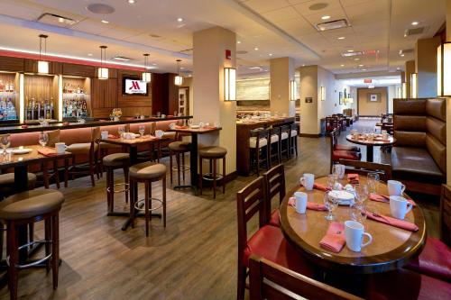 a restaurant with tables and chairs and a bar at Houston Marriott North in Houston