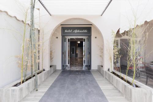 a hallway leading to a building with a door at Aphrodite Beach Hotel Corfu in Roda