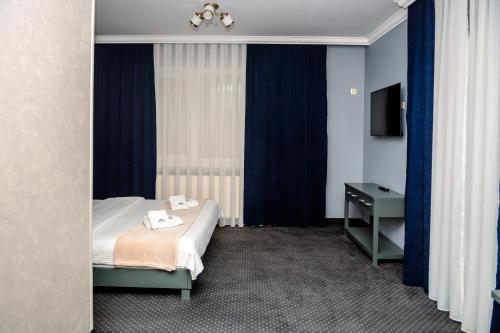 a hotel room with a bed and a window at Севеней Готель in Bukovel