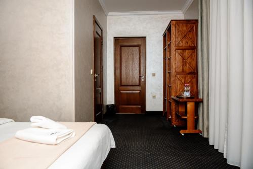 a hotel room with a bed and a wooden door at Севеней Готель in Bukovel