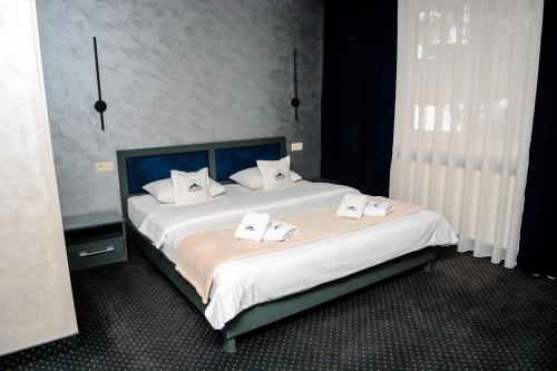a bedroom with a large bed with two white towels at Севеней Готель in Bukovel