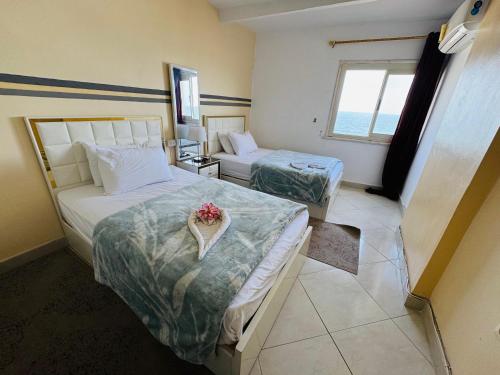 a hotel room with two beds and a window at ALEX HOMES - Sporting Cozy Apartments with Direct Sea View in Alexandria