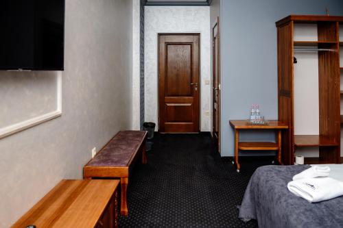 a room with a bed and a table and a door at Севеней Готель in Bukovel