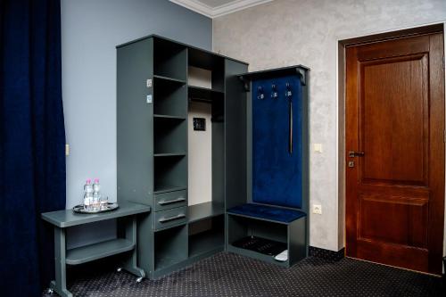 a room with a closet with a blue chair and a table at Севеней Готель in Bukovel
