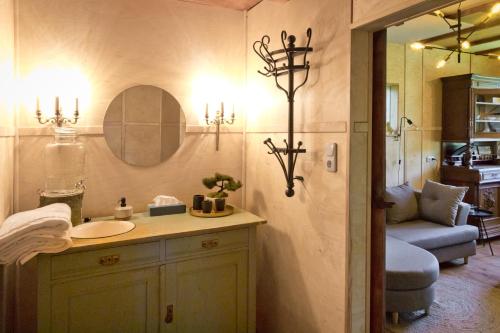 a bathroom with a sink and a mirror and a couch at Baumhaus Beletage in Bockhop