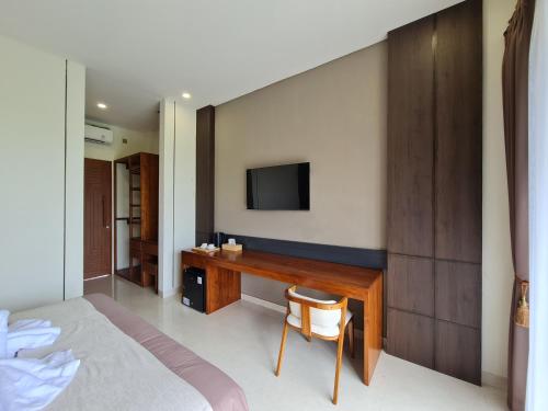 a bedroom with a desk and a tv on a wall at DKD ROOM Pererenan Canggu in Canggu