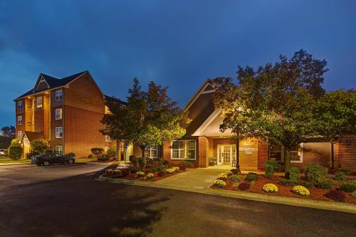 a house with a car parked in the driveway at Residence Inn by Marriott Detroit Livonia in Livonia