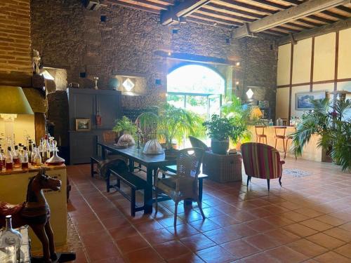 une salle à manger avec une table et des chaises et une fenêtre dans l'établissement Maison d'Hotes Le Chai d'Armagnac, à Monguillem