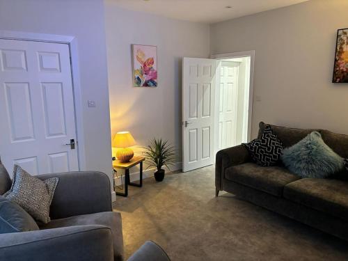a living room with two couches and a door at 3 Bedroom home, with 4 beds, parking, walk to station & town centre families and business visitors welcome in Ormskirk