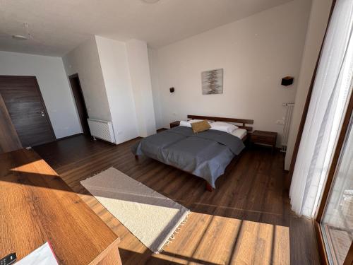 a bedroom with a bed and a wooden floor at Casa Leone Hotel&Restaurant in Popova Shapka