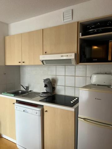 une cuisine avec un évier et une cuisinière four supérieur dans l'établissement Appartement Les chalets de Puy-St-Vincent 1700, à Puy-Saint-Vincent