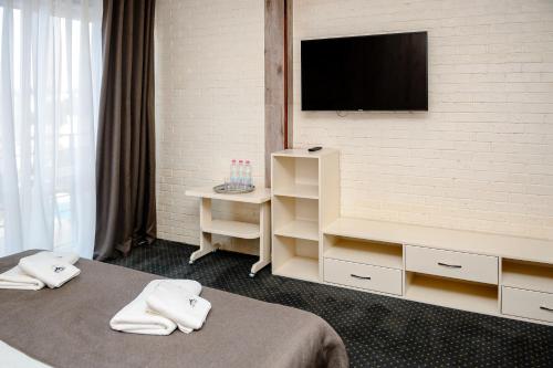 a hotel room with two beds and a flat screen tv at Севеней Готель in Bukovel