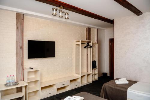 a room with a tv on a brick wall at Севеней Готель in Bukovel
