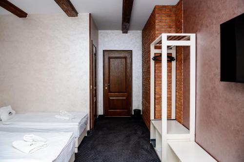 a room with two beds and a mirror and a door at Севеней Готель in Bukovel