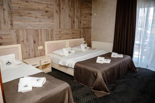 a hotel room with two beds with towels on them at Севеней Готель in Bukovel