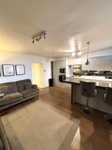 a living room with a couch and a kitchen at The Gardners apartment in City centre with parking in Edinburgh