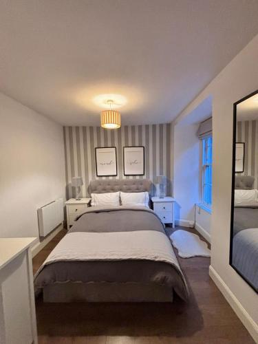 a bedroom with a large bed and a chandelier at The Gardners apartment in City centre with parking in Edinburgh