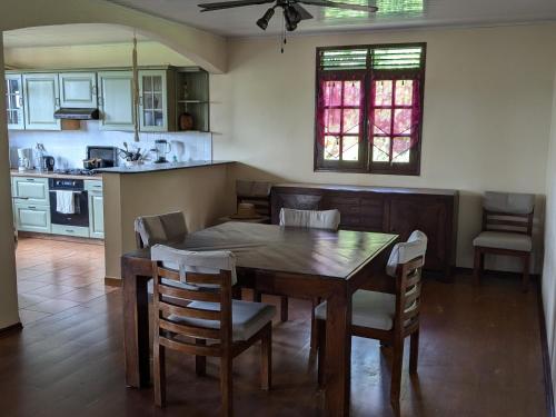 a kitchen and dining room with a wooden table and chairs at La Gaëtine in Ducos