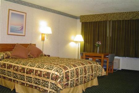 a hotel room with a bed and a desk at Sunset Inn Lake Oroville in Oroville