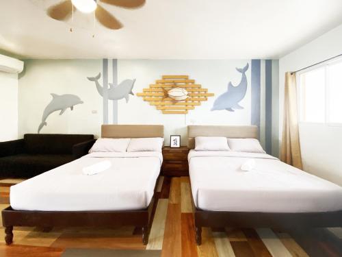 a room with two beds and a couch at Kalachuchi Inn 薄荷雞蛋花旅宿 in Panglao