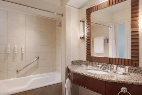 a bathroom with a sink and a tub and a mirror at Santiago Marriott Hotel in Santiago