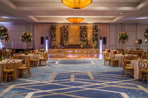 a banquet hall with tables and chairs and a stage at The Woodlands Waterway Marriott Hotel and Convention Center in The Woodlands