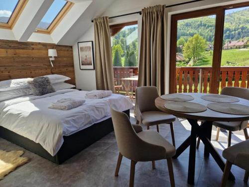 a bedroom with a bed and a table and chairs at Beskidylla CHALET in Ustroń