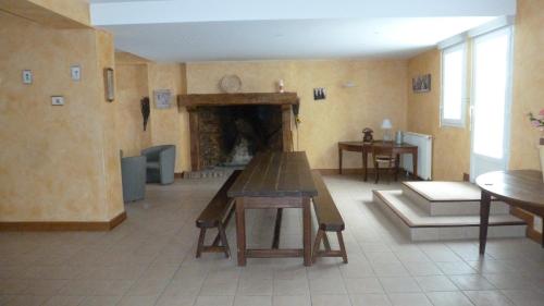 ein Wohnzimmer mit Tisch und Kamin in der Unterkunft Gîte de Pailherols in Pailherols