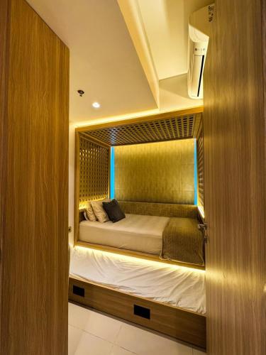 a bedroom with a bed in a small room at Apt Embarcadero 2BR with Netflix & Pool by Damaresa in Pondokpucung