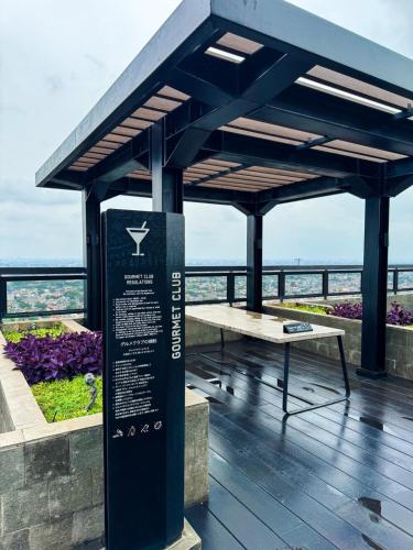 a pavilion with a table and a bench on a deck at Apt Embarcadero 2BR with Netflix & Pool by Damaresa in Pondokpucung