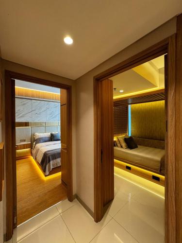 a bedroom with a bed and a bedroom with a window at Apt Embarcadero 2BR with Netflix & Pool by Damaresa in Pondokpucung