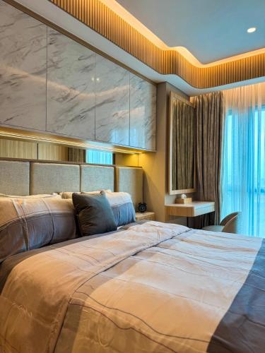 a bedroom with a large bed with a large wall at Apt Embarcadero 2BR with Netflix & Pool by Damaresa in Pondokpucung